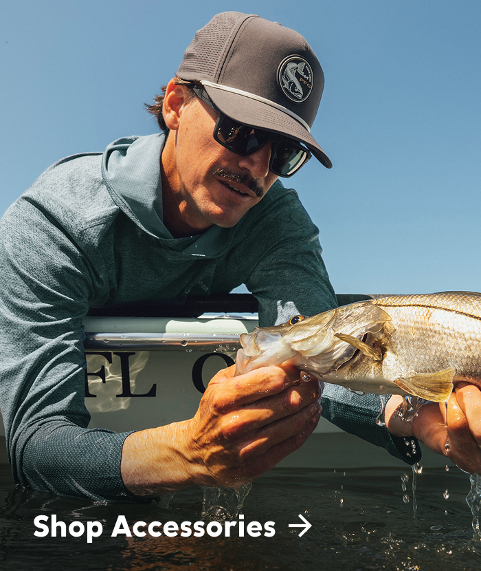 Shop Accessories. A close up of a man holding a fish. 
