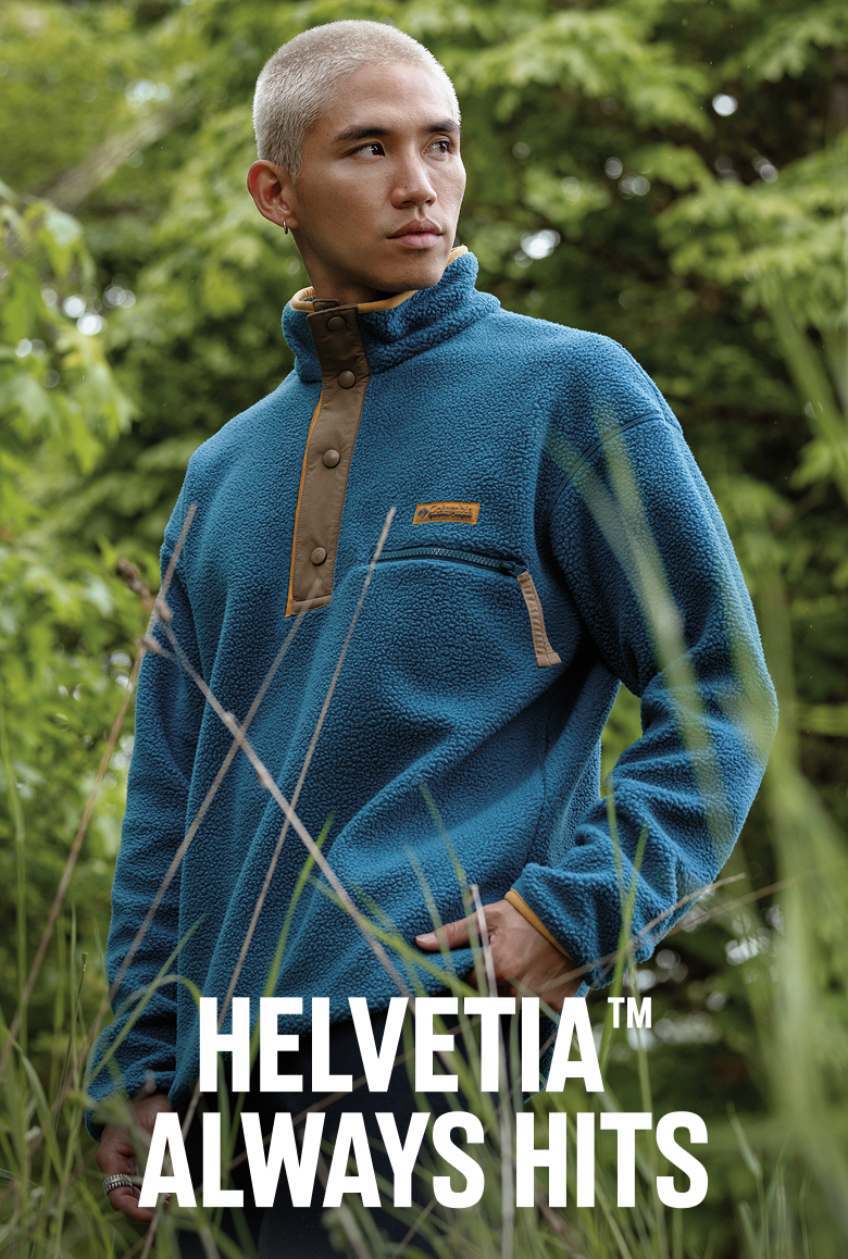 A man wearing a blue fleece pullover in a forest with text: HELVETIA ALWAYS HITS