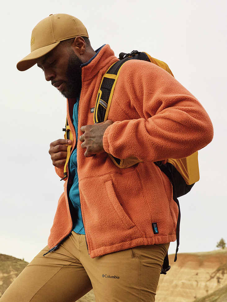 Man hiking in an orange fleece jacket.