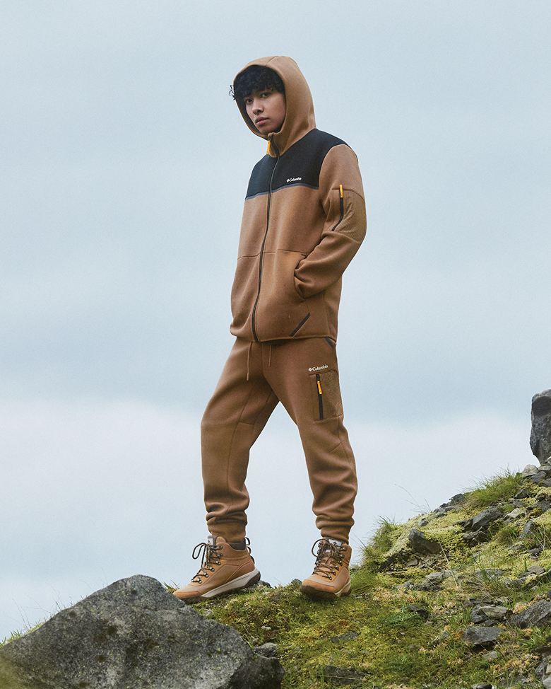 A man wearing a tan sweat set outside