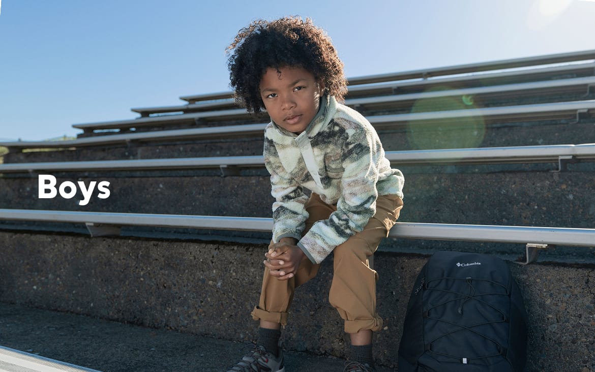 A little boy sitting on bleachers with a backpack with text: Boys