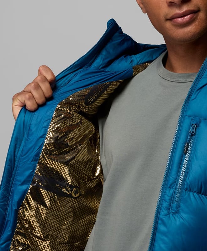 Close-up of a man opening his blue puffer to reveal a gold interior.