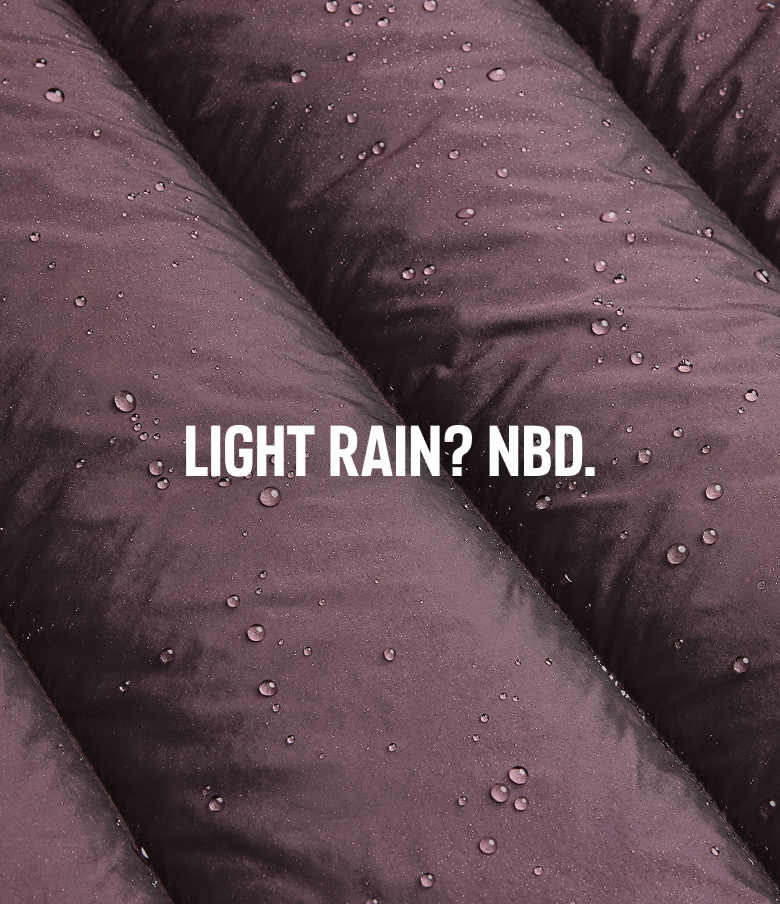 Close-up of moisture beading on purple fabric with text: LIGHT RAIN? NBD.